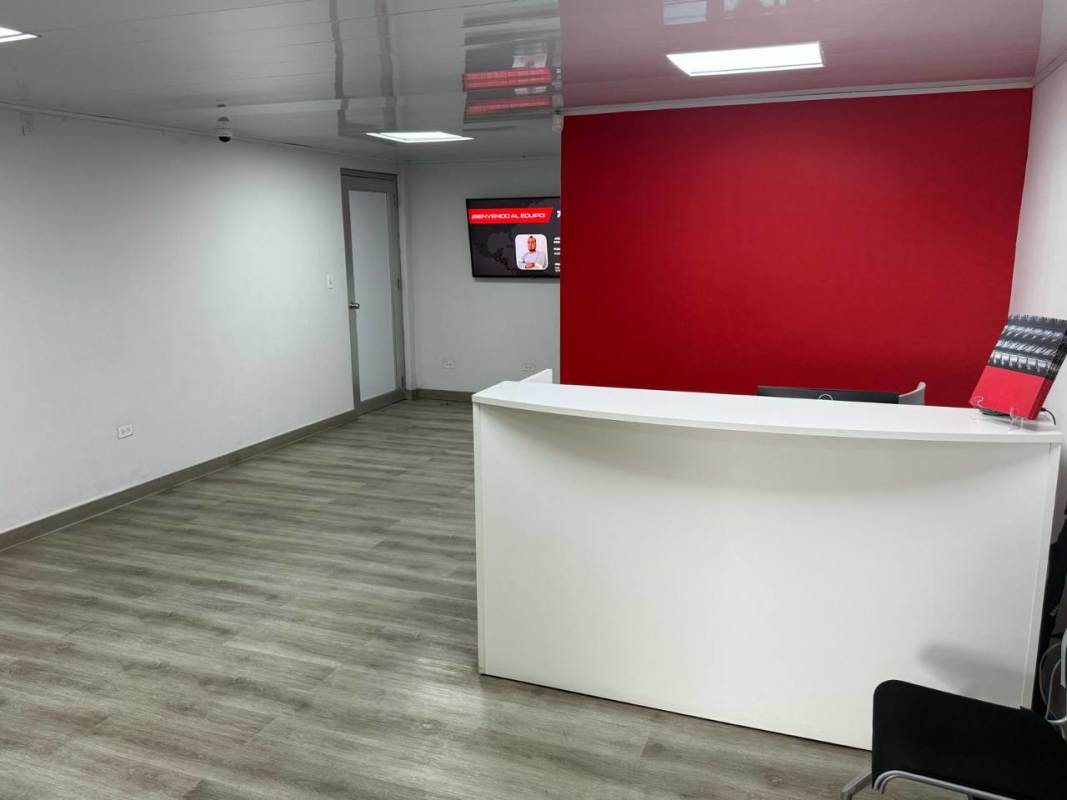 Modern office reception with red accent wall and wood flooring in warehouse Juan Díaz