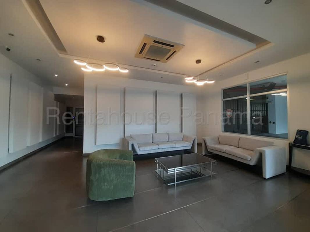 Stylish lobby with modern chandelier, white sofas, green ottoman at PH Oasis San Francisco Panama