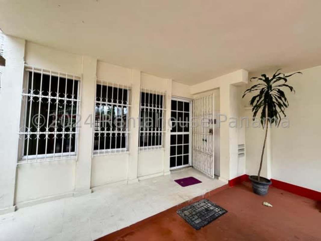 Covered porch with security bars and gate at Chanis residential house Panama