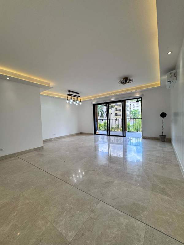 Large living room with marble floors, recessed ceiling lights and sliding doors in Embassy Club Clayton