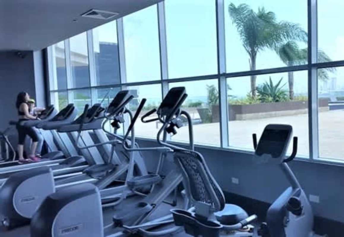 Modern gym with cardio equipment and panoramic window views in PH Country Club Costa del Este Panama