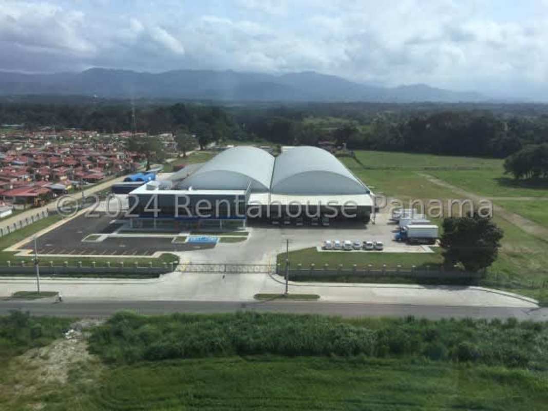 Curved roof warehouses with surrounding green agricultural land in Panama Pacora