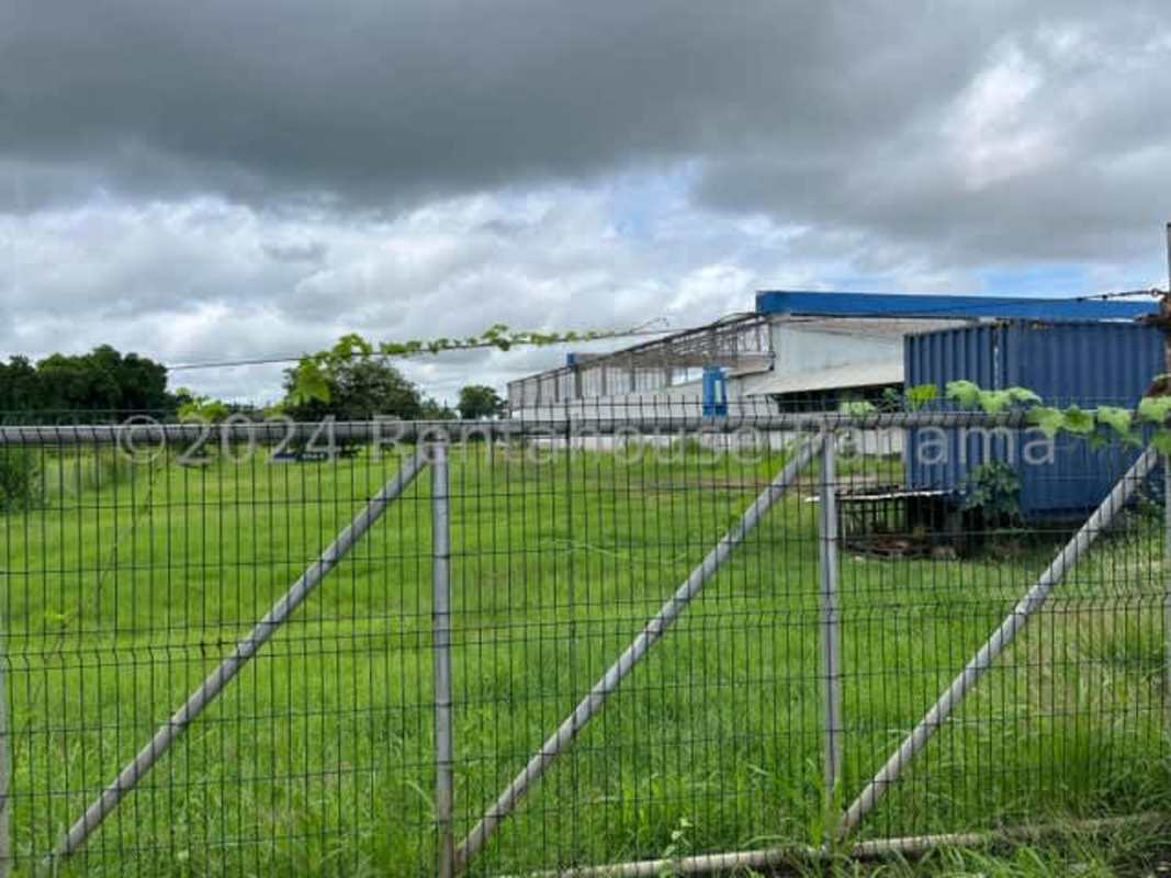 Large warehouse structure with chain link fencing and open land Pacora Panama