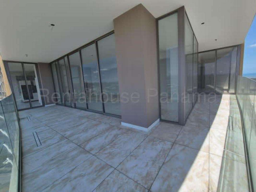 Modern kitchen with marble countertop, island, and floor-to-ceiling windows with views in La Maison by Fendi Panama