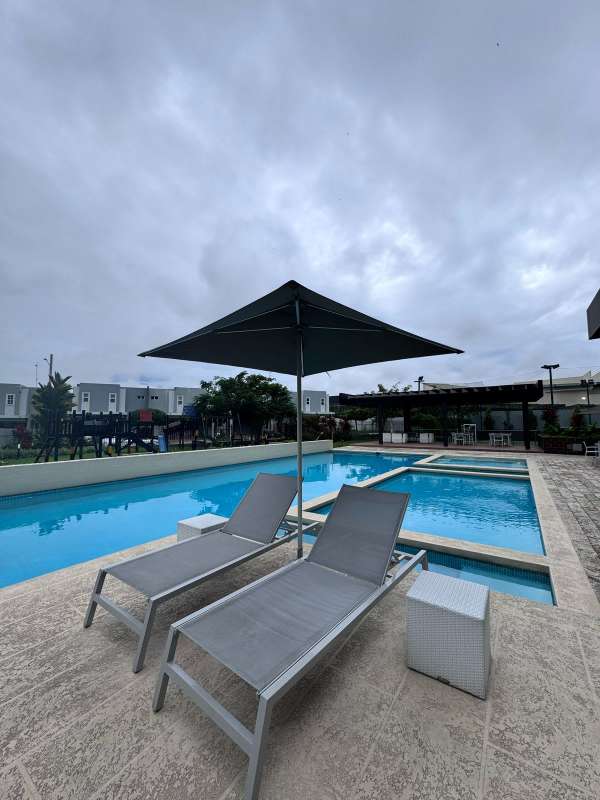 Community pool area with umbrellas, dining spaces in Brisas del Golf Panama