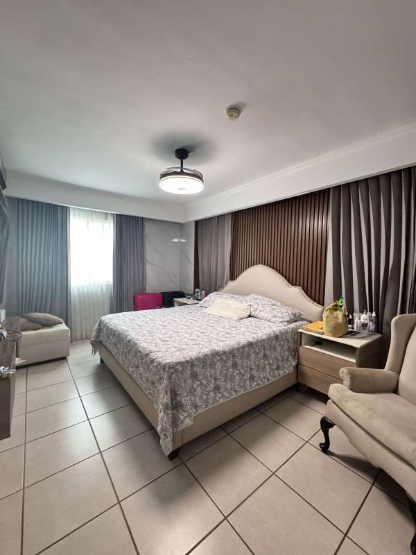 Large bedroom with upholstered headboard, curtains, and light decor in Paseo del Norte