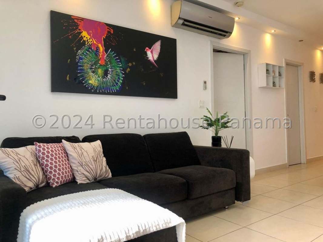 Living room with sectional sofa, large windows, ocean view balcony furnished apartment in PH Pacific Point