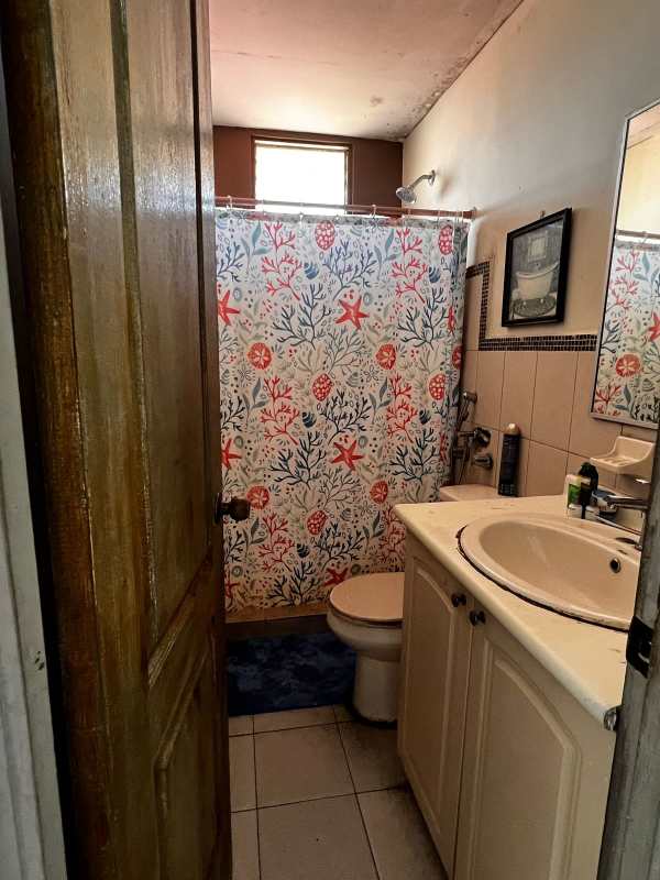 Full bathroom with single vanity sink, shower curtain in apartment Río Abajo