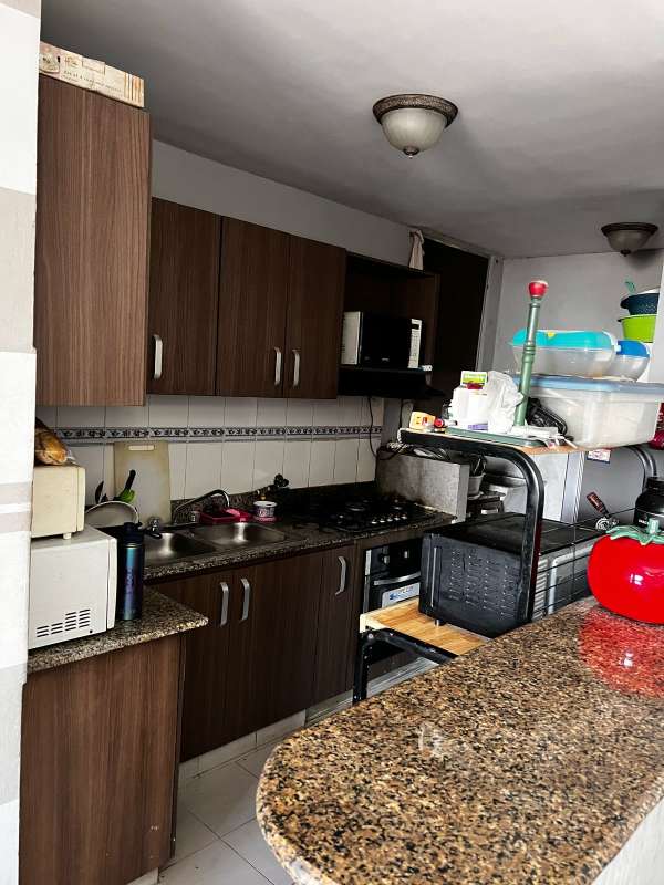 Compact open kitchen with cabinets and granite countertop in apartment Panama