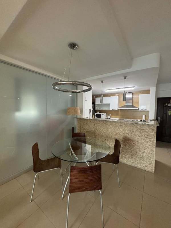 Galley kitchen layout with granite counters, appliances and tile backsplash in Altos de Golf Panama
