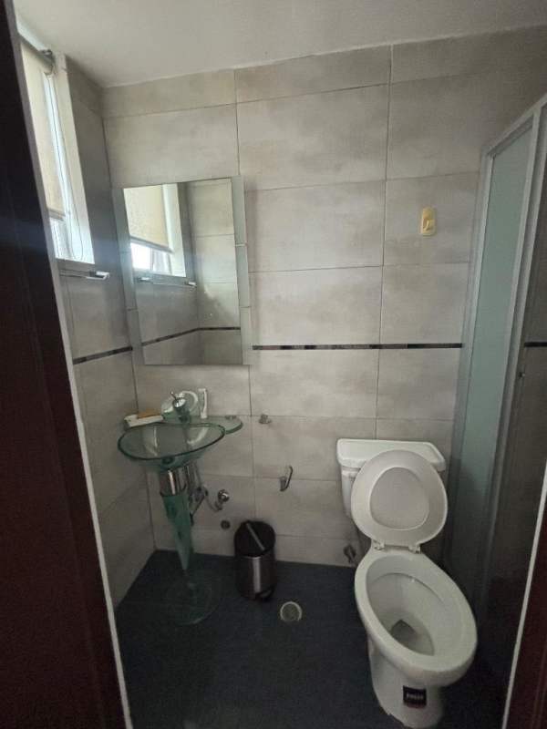 Modern bathroom with glass sink, tile walls, shower enclosure PH Terramar Panama City