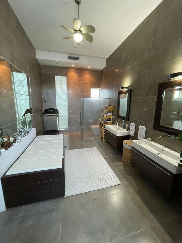 Bright dining area with full height glass windows, woven chairs and lush tropical backdrop in PH Bianco Loft