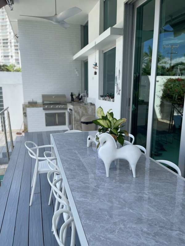 Outdoor patio featuring marble dining table, built-in BBQ, fridge, and modern finishes PH Bianco Loft Panama