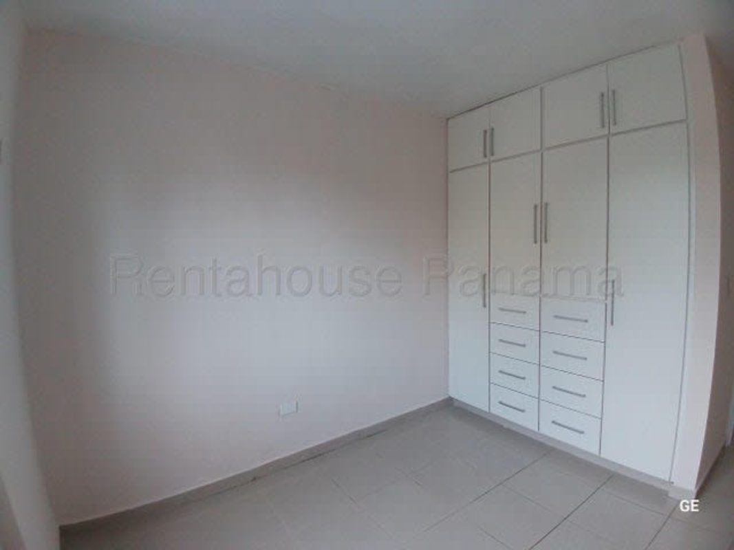 Bright empty living room with ceramic floor, large window and glass door PH Parque Lefevre apartment Panama