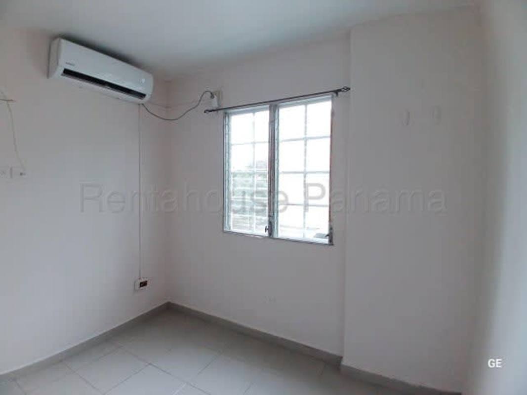Apartment bedroom with split-type AC, tiled floors, and window with city view in Parque Lefevre Panama