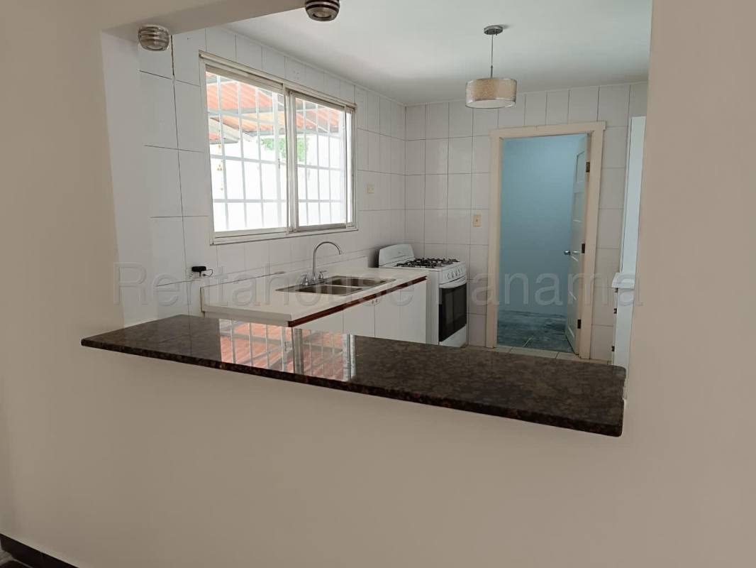 Interior kitchen view with granite counter and white tiles in Brisas del Golf house Panama
