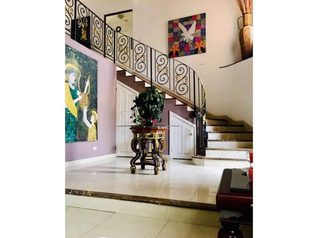 Foyer with curved staircase, wall art, and decorative accents Costa Bay Panama