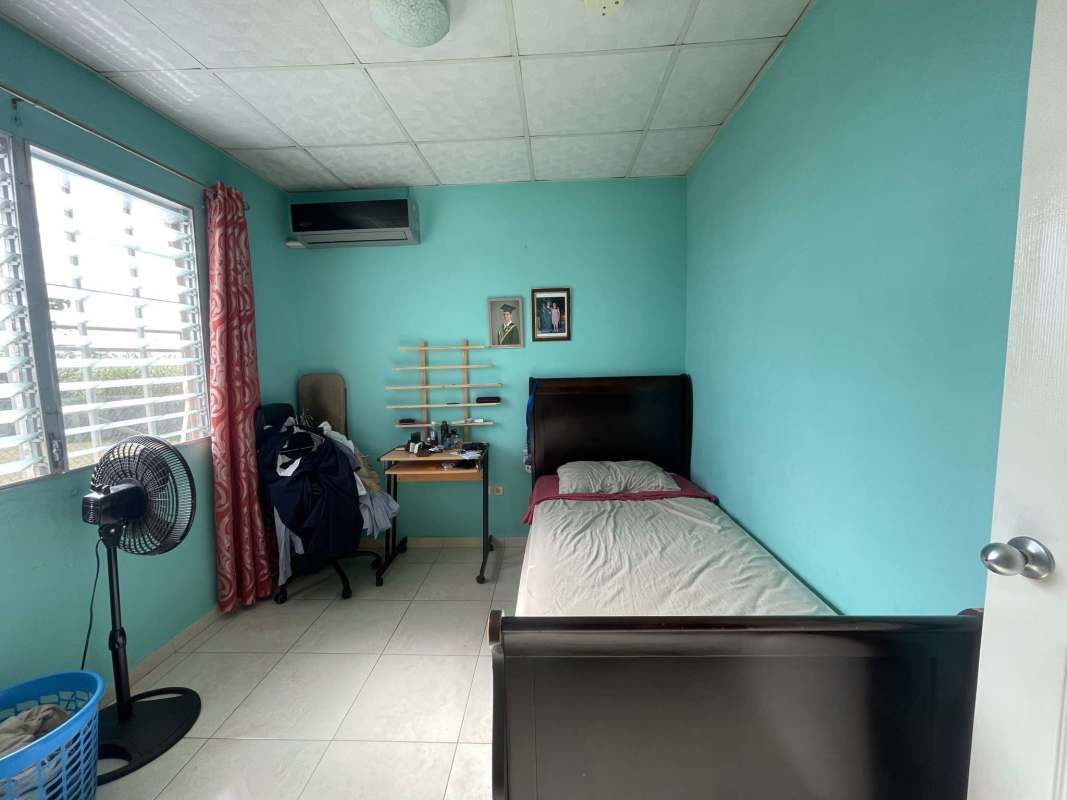 Bedroom with blue walls large window AC red curtains PH Colinas del Lago Las Cumbres Panama