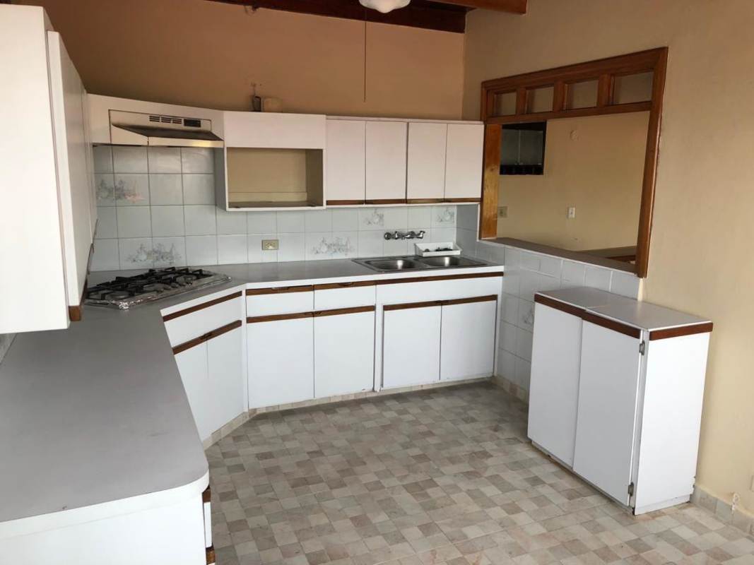 White cabinet kitchen with tile backsplash, gas stove, pass-through window El Dorado Panama