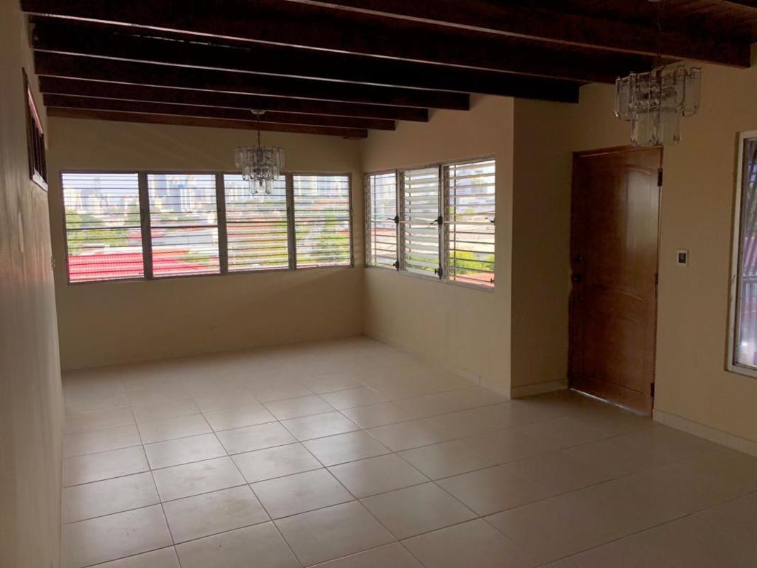 Outdoor tiled patio with roofed seating, garden, and plants in El Dorado house Panama City