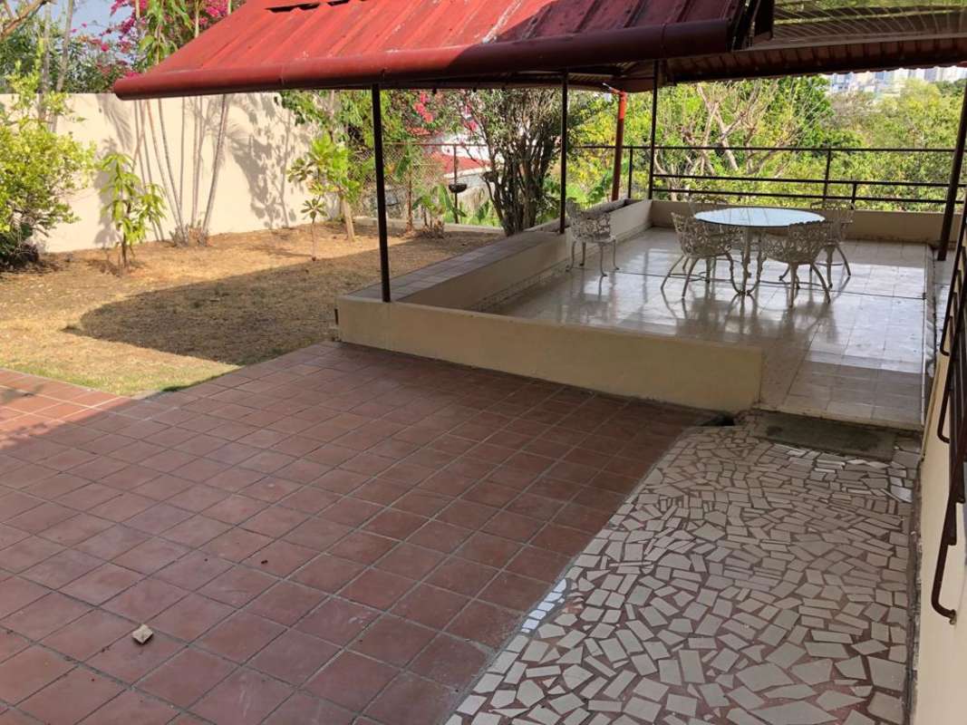 Outdoor patio with tiled floor, red awning cover, elevated seating, backyard garden El Dorado Panama