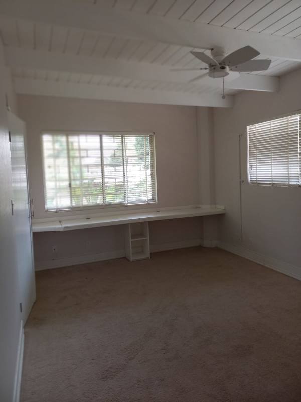 Large living space with windows, ceiling fan and tiled floor of a duplex rental La Boca Panama