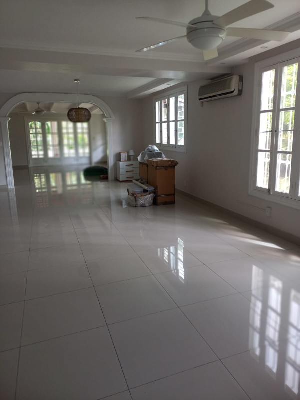 Living area with arched entry, French windows, beams ceiling in family home La Boca Balboa Panama