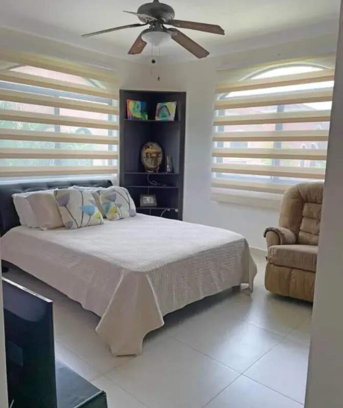 Contemporary bedroom with large windows, ceiling fan and natural light at Clayton rental home