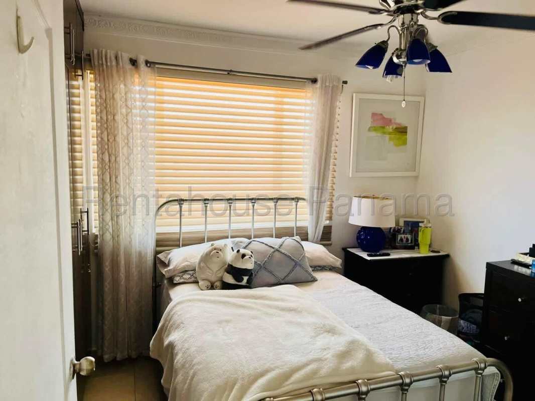 Bedroom with large window, ceiling fan blue accents plush toys Villa Tivoli Panama City