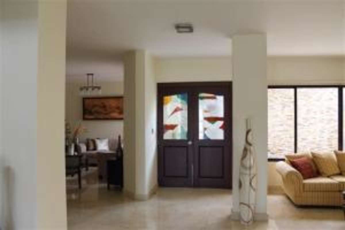 Mansion backyard with swimming pool, lush landscaping and covered patio in gated Costa del Este Panama