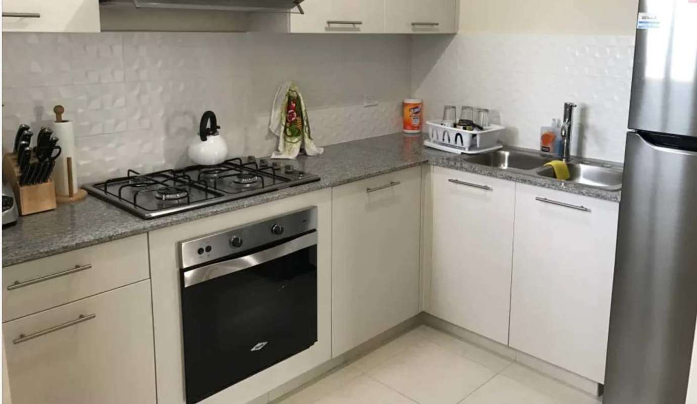 Apartment kitchen with granite countertops, stove and cabinets in Costa Sur Panama