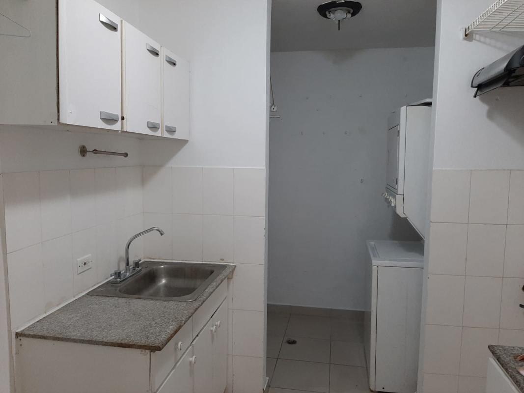 Small kitchen with granite counter, white cabinets, stacked washer dryer PH Vista del Golf Parque Lefevre Panama