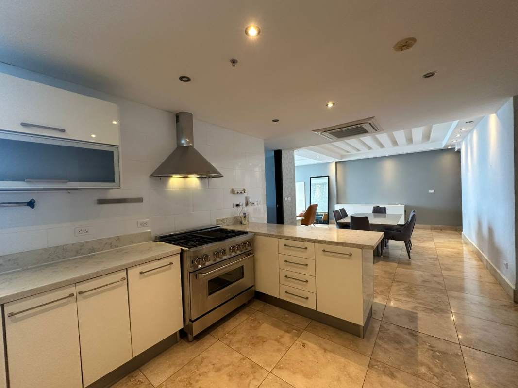 Modern kitchen with island, marble counters, open to dining PH Coco del Mar