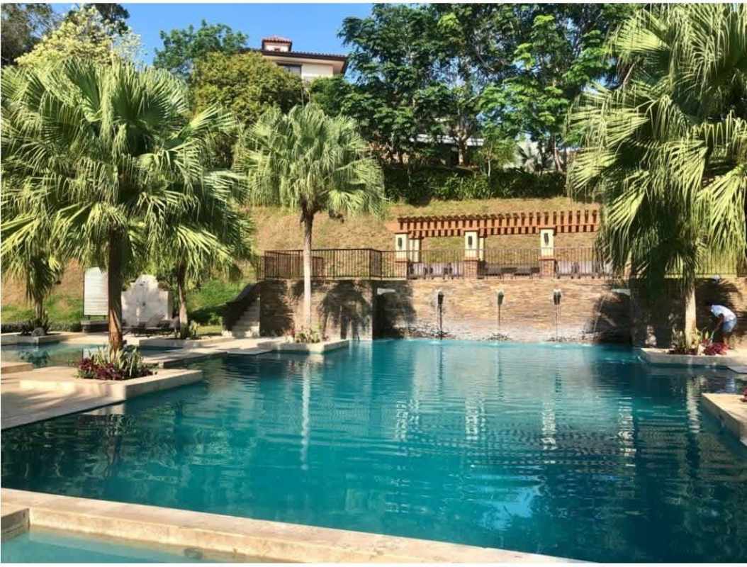Resort-style swimming pool surrounded by tropical landscaping at PH Clayton Park Panama City