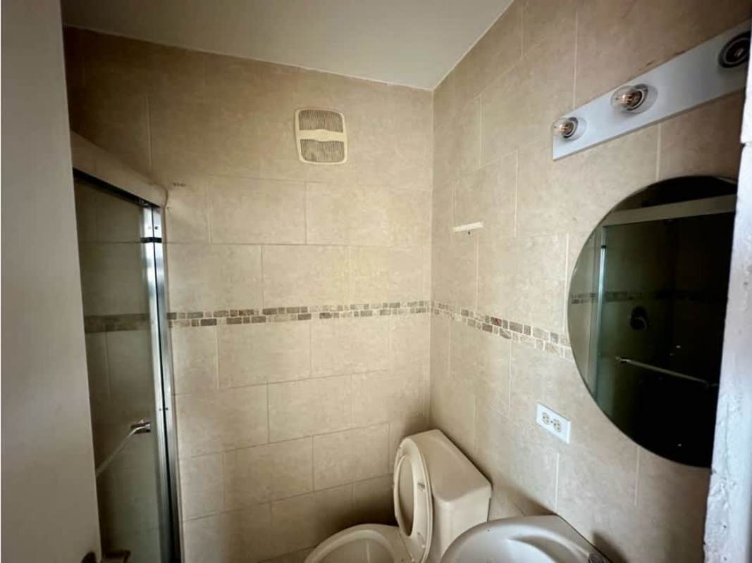 Compact bathroom with glass shower, beige ceramic tiles, modern fixtures at PH Portofino Panama