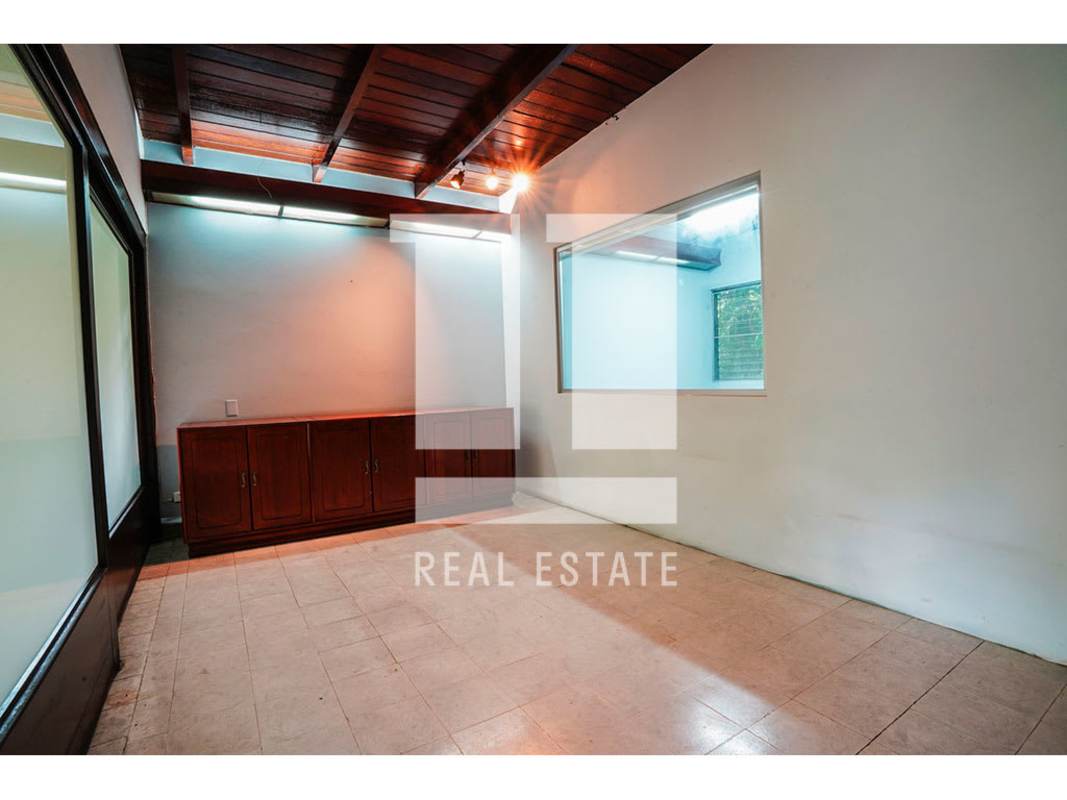 Bathroom with green and white tiles, walk-in shower and pedestal sink in commercial house Via Porras Panama