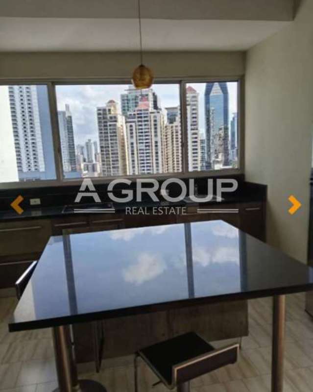 Kitchen with island, dark countertops, pendant lighting, and large panoramic windows overlooking Panama City skyline at PH Denovo