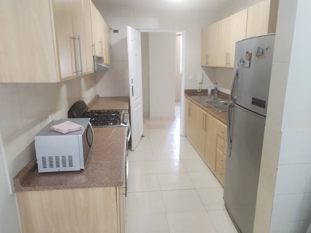 Galley kitchen with granite counters and stainless appliances PH Aurora Tower Panama