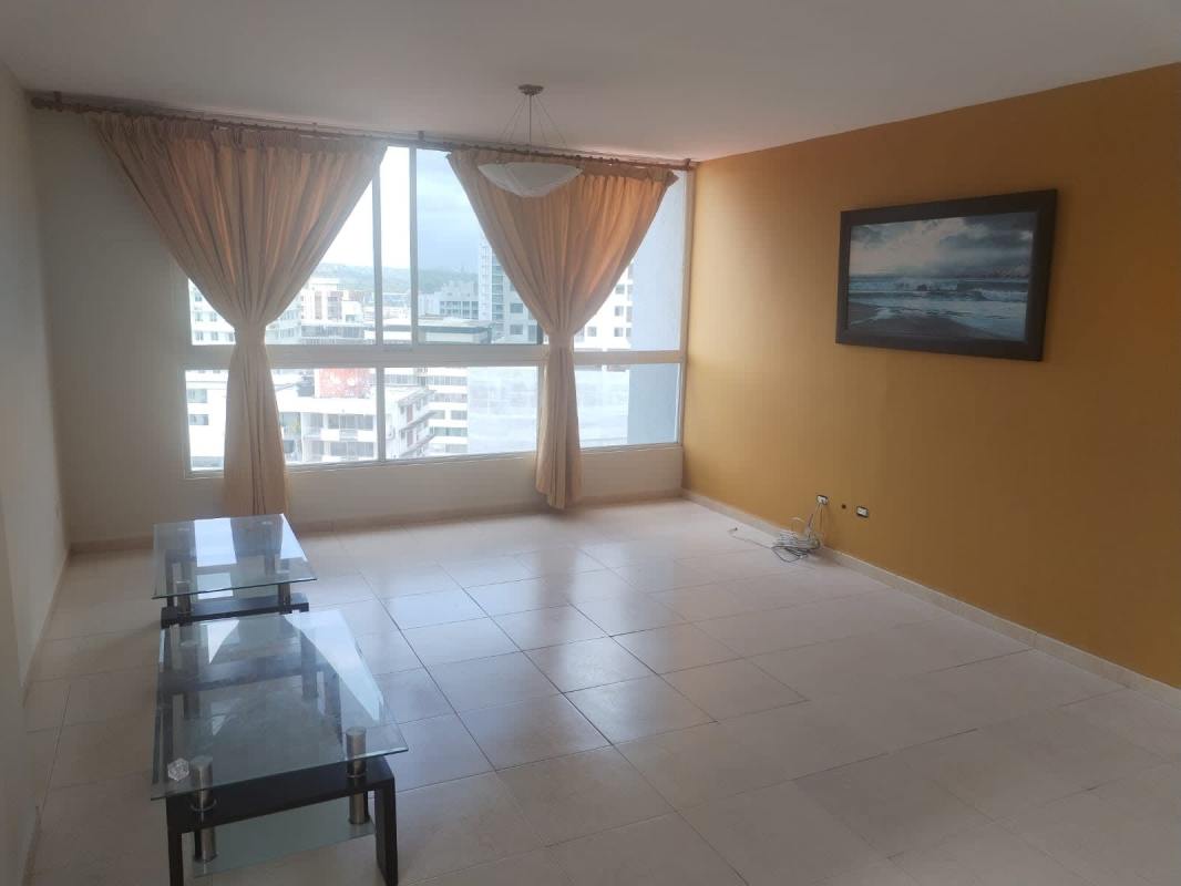 Living room with yellow accent wall and large city view window PH Aurora Tower Panama