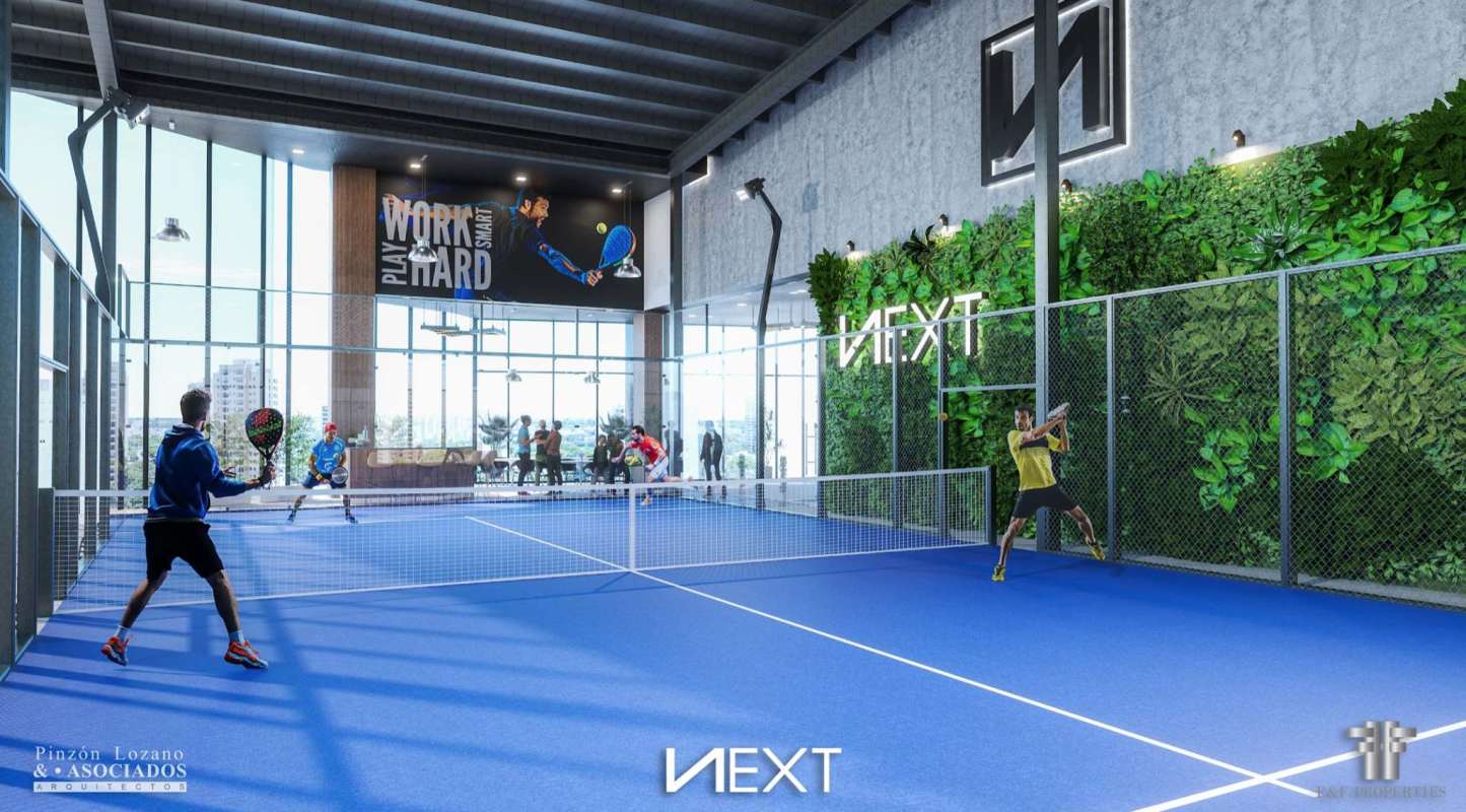 Blue indoor padel tennis court with green wall and city view PH NEXT Coco del Mar