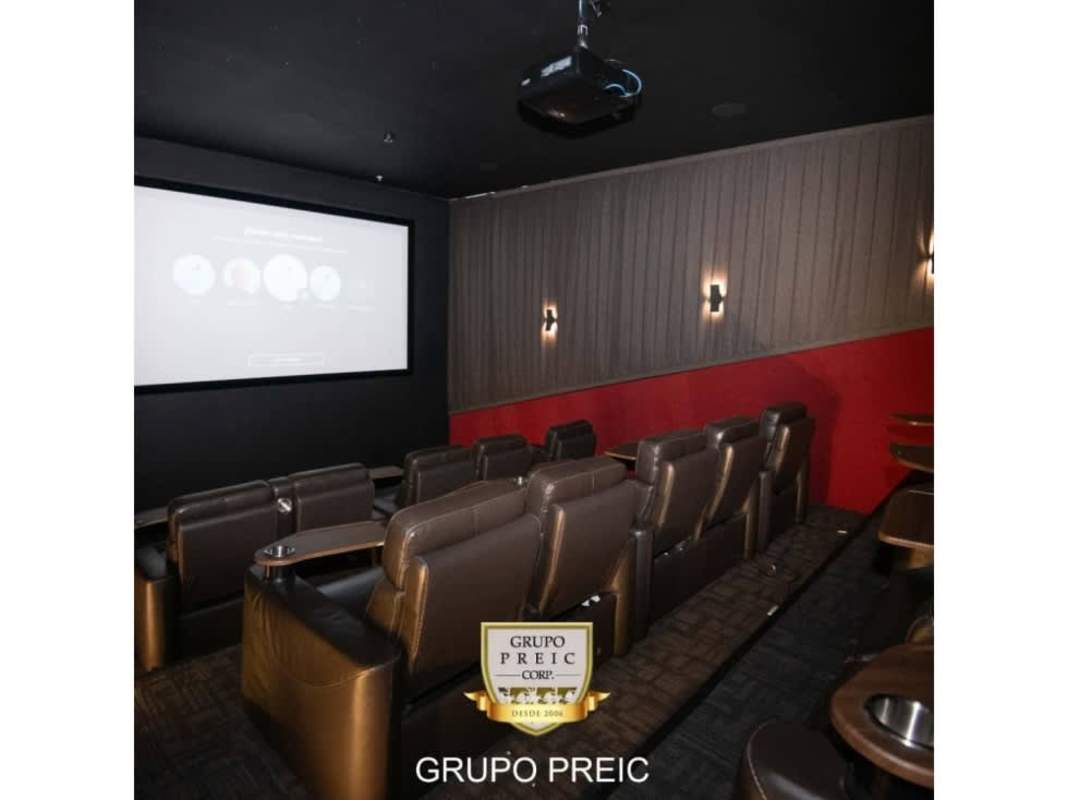 Modern home theater room with leather tiered seats, projector screen in PH Country Club Costa del Este