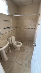 Simple bathroom with tiles, pedestal sink, small window in Brisas del Golf Arraiján single-family home