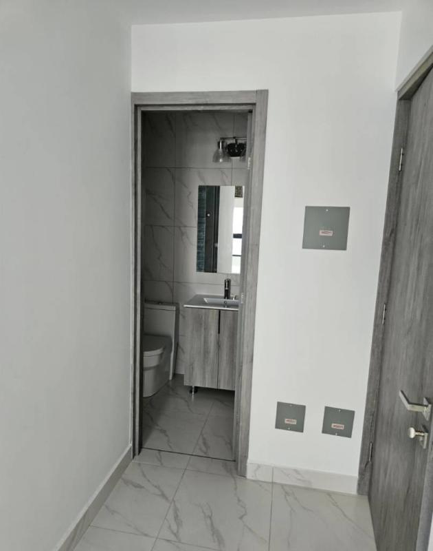 Large modern bedroom with tile floors and city view window at PH The Gray Obarrio Panama