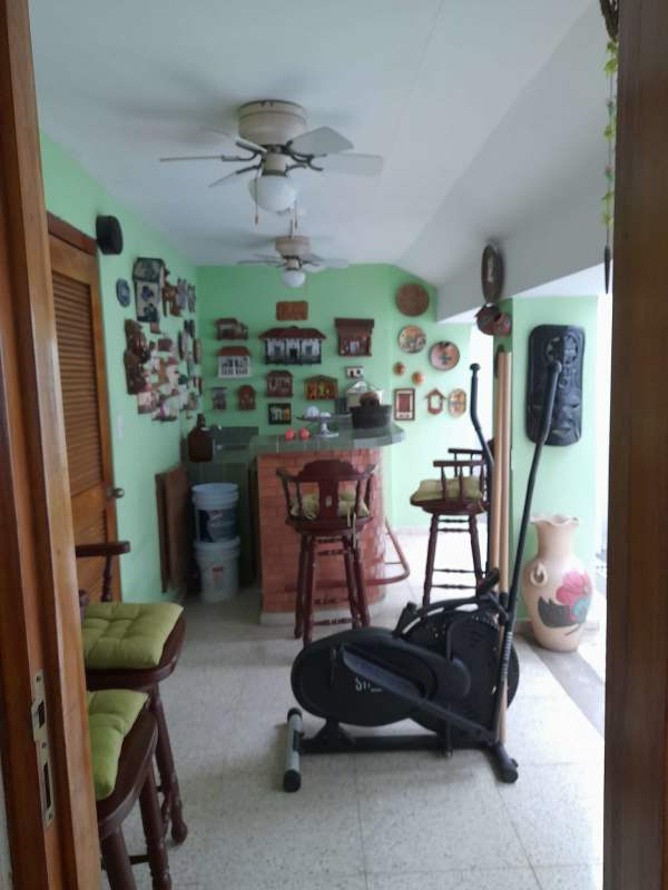 Living room with large windows and garden views, traditional furniture in La Alameda Panama