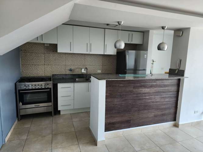Kitchen with granite breakfast bar, stainless appliances and pendant lighting in apartment El Crisol Villa Lucre