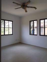 Large bedroom with big windows, ceiling fan, and ceramic floor in Panama beach house