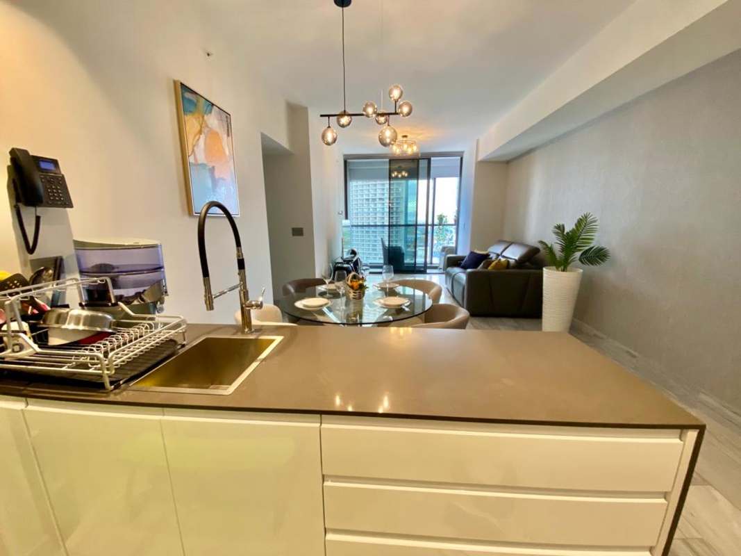 Italian kitchen with island, granite counters, dining area at PH Nuovo Armani Panama City