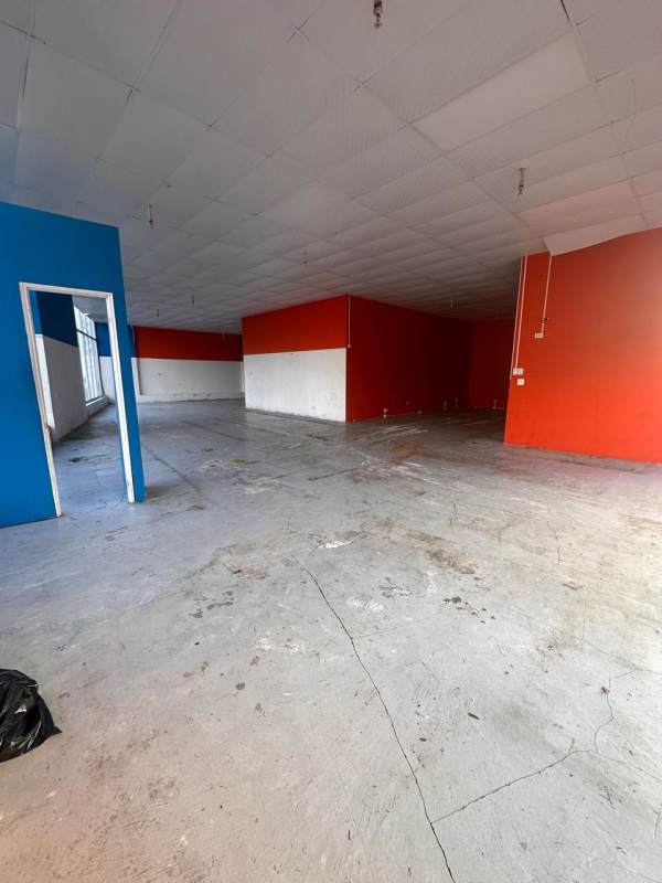 Empty large commercial space with concrete floor painted walls overhead lighting Via España Panama City