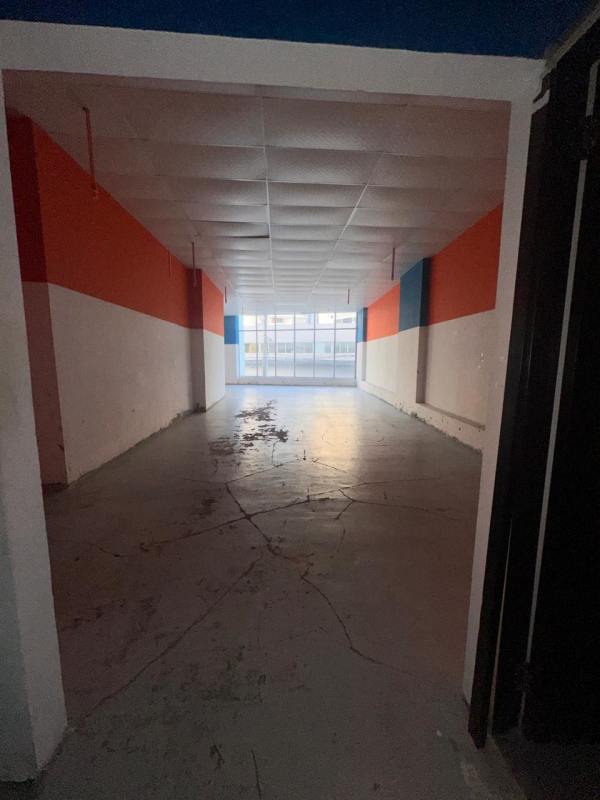 Commercial unit with large street-facing window open space striped painted walls concrete floor