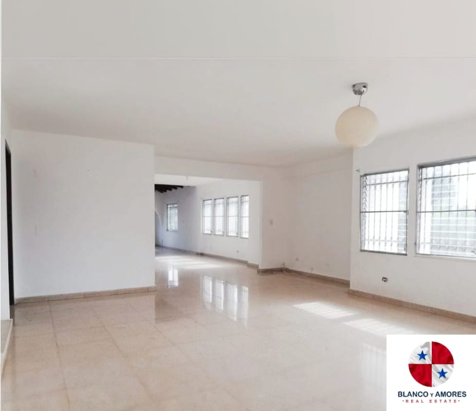 Large living room with wood beams, large windows, arched doorways and tile floor in Villa de las Fuentes house for rent Panama